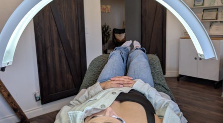 Client relaxing under LED light therapy at Claire'ity Care in Blackfalds, Alberta, CA.