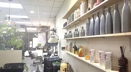 Interior of Garden Hair Beauty Salon in New York, New York, US with shelves of hair products and salon chairs.