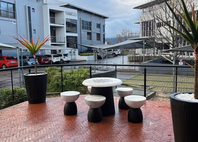 Outdoor seating area at Anthea Hairstylist, Stellenbosch, Western Cape, ZA with chic tables and plants.