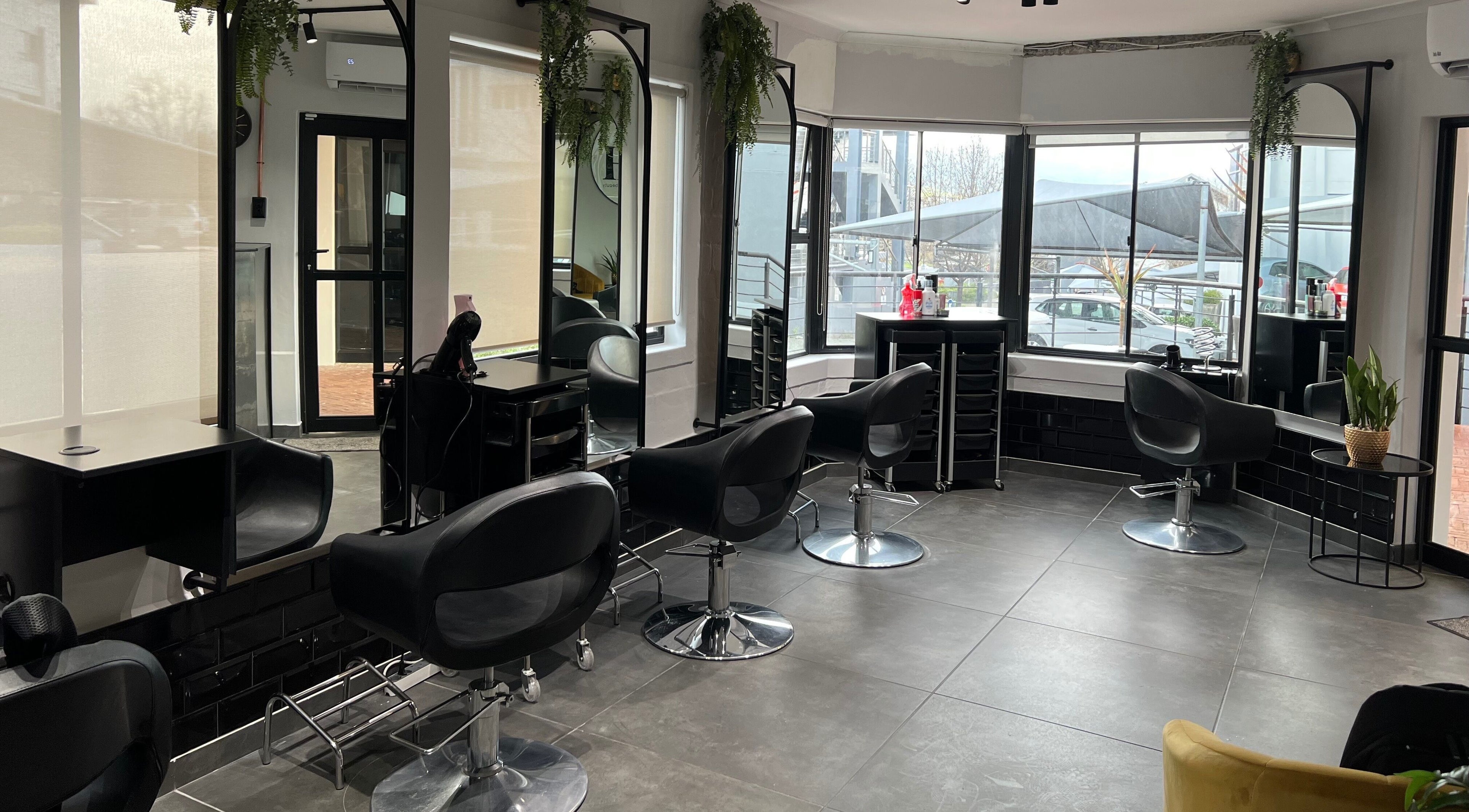 Modern salon interior at Anthea Hairstylist in Stellenbosch, Western Cape, ZA with stylish black chairs.