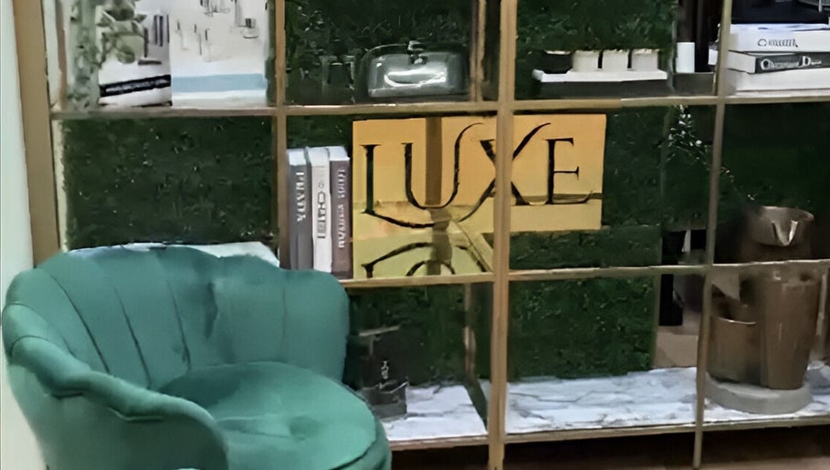 Elegant green chair beside decor with Luxe Beauty Bar Sydney logo, Earlwood, New South Wales, AU.