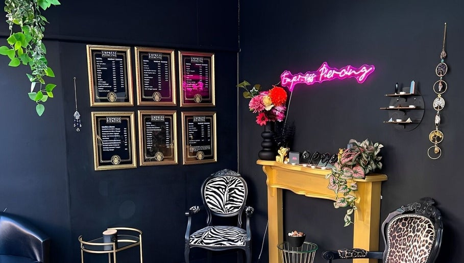 Empress Piercing Cardiff lounge with stylish decor in Cardiff, Wales, GB, featuring neon sign and framed art.