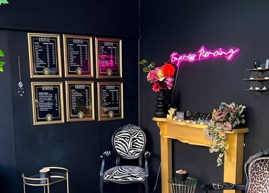 Empress Piercing Cardiff lounge with stylish decor in Cardiff, Wales, GB, featuring neon sign and framed art.