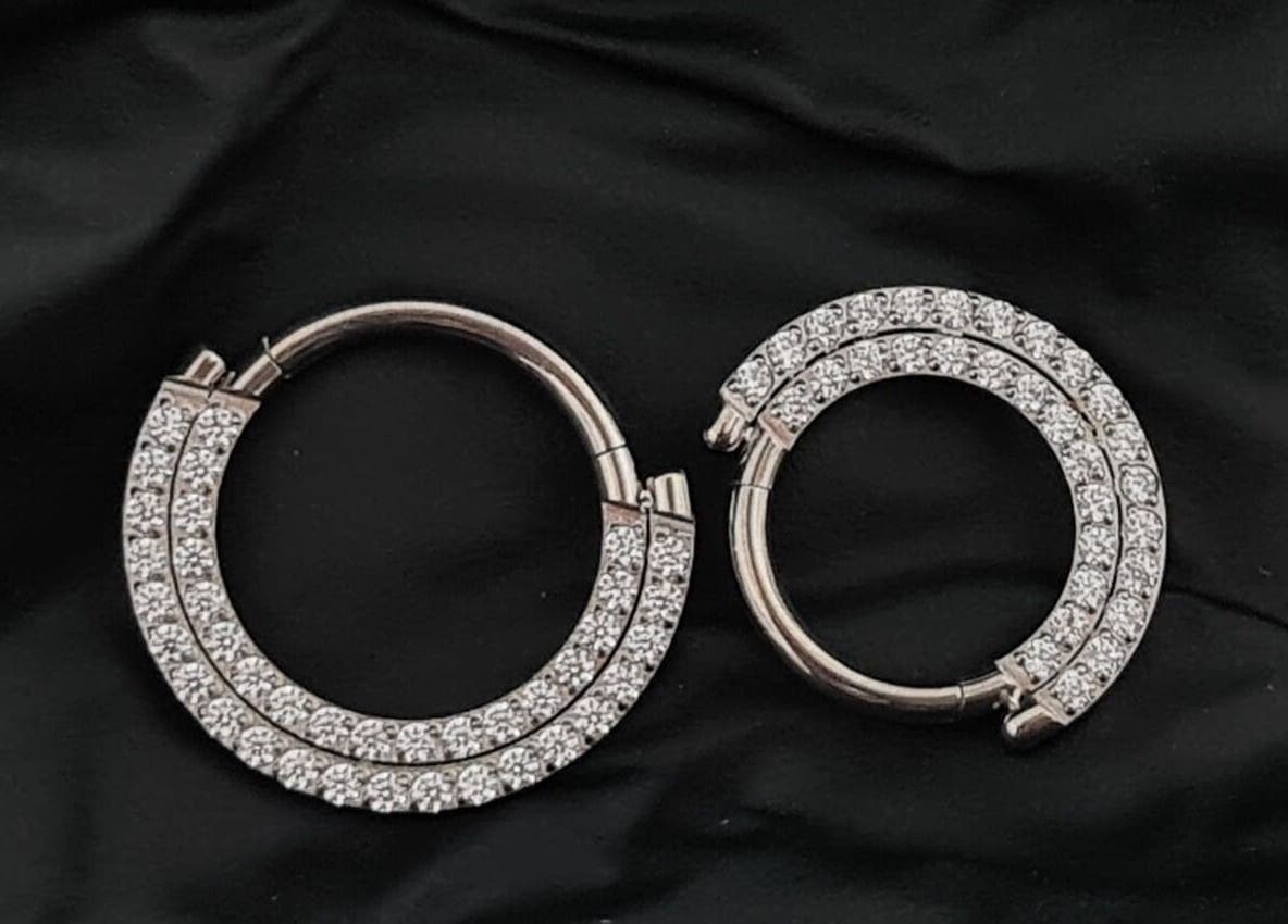Elegant diamond hoop earrings at Empress Piercing Cardiff, Cardiff, Wales, GB, elegantly displayed on black fabric.