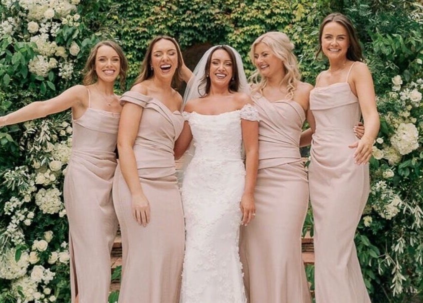 Smiling bridesmaids with bride at FMN Studio, Mungret Village, County Limerick, IE amidst lush green backdrop.
