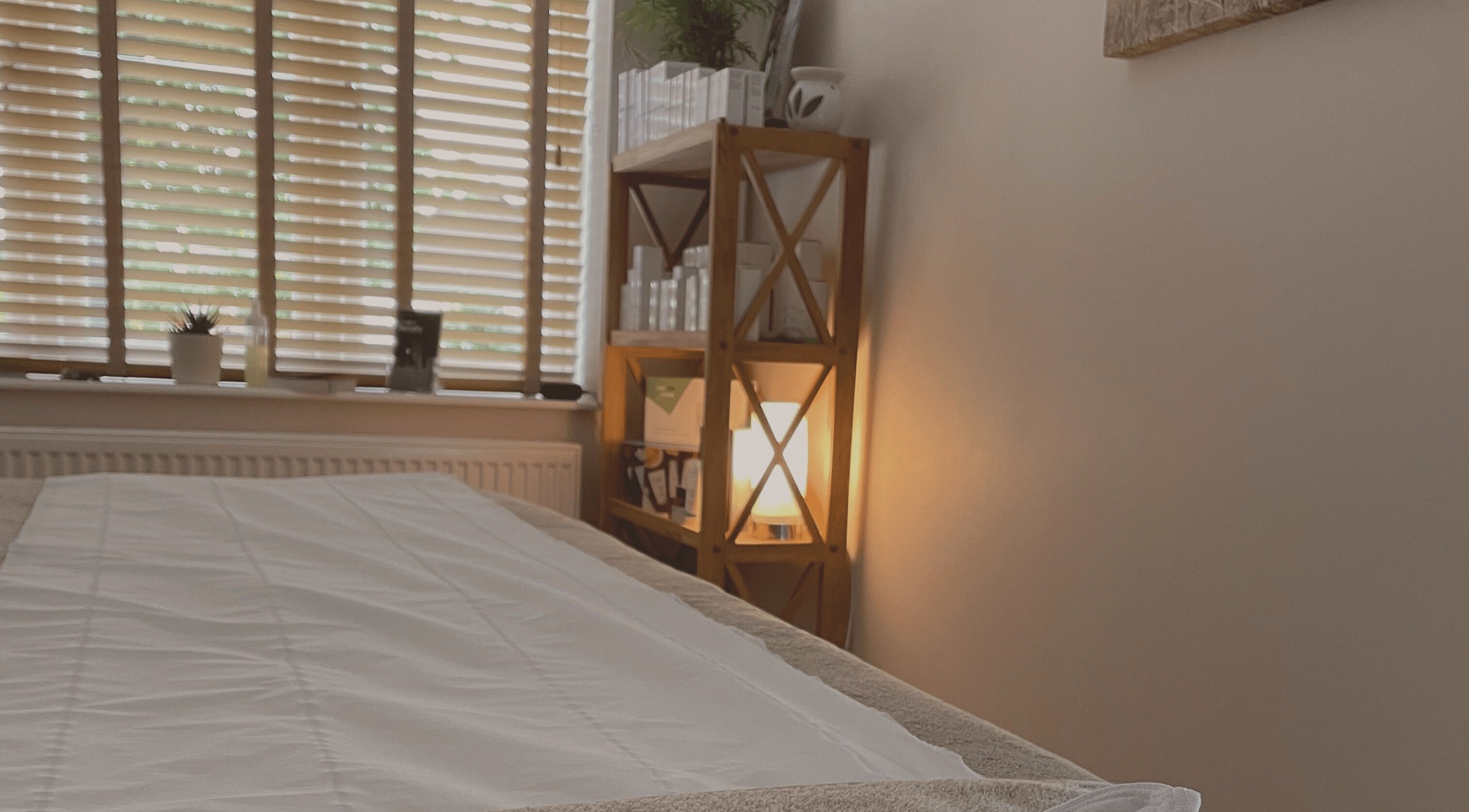 Tranquil therapy room at DL Beauty Clinic, Shipston-on-Stour, England, GB, with a cozy bed and warm lighting.