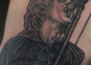 Detailed tattoo of a singer at Loved by Few, Carlisle, England, GB showcasing intricate artistry.