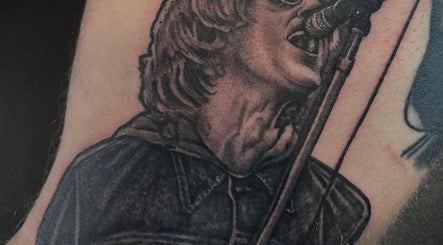Detailed tattoo of a singer at Loved by Few, Carlisle, England, GB showcasing intricate artistry.