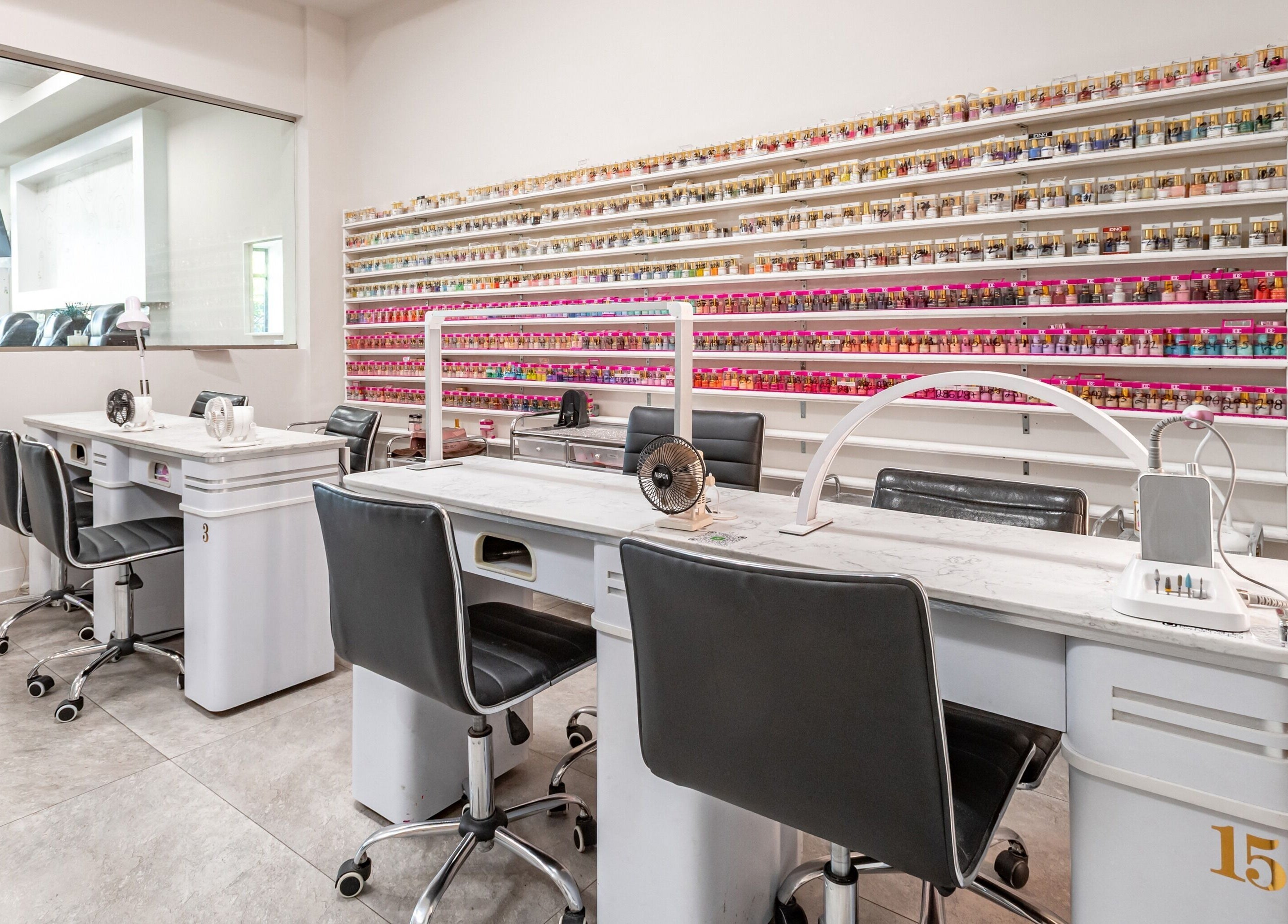 Modern manicure station at Lash and Nail Spa in Miramar, Florida, US, with vibrant nail polish wall.