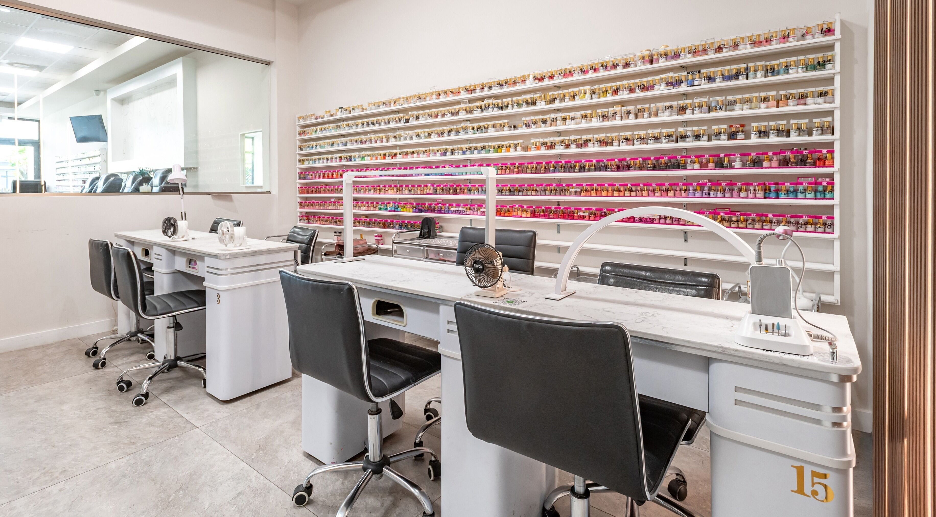 Modern manicure station at Lash and Nail Spa in Miramar, Florida, US, with vibrant nail polish wall.