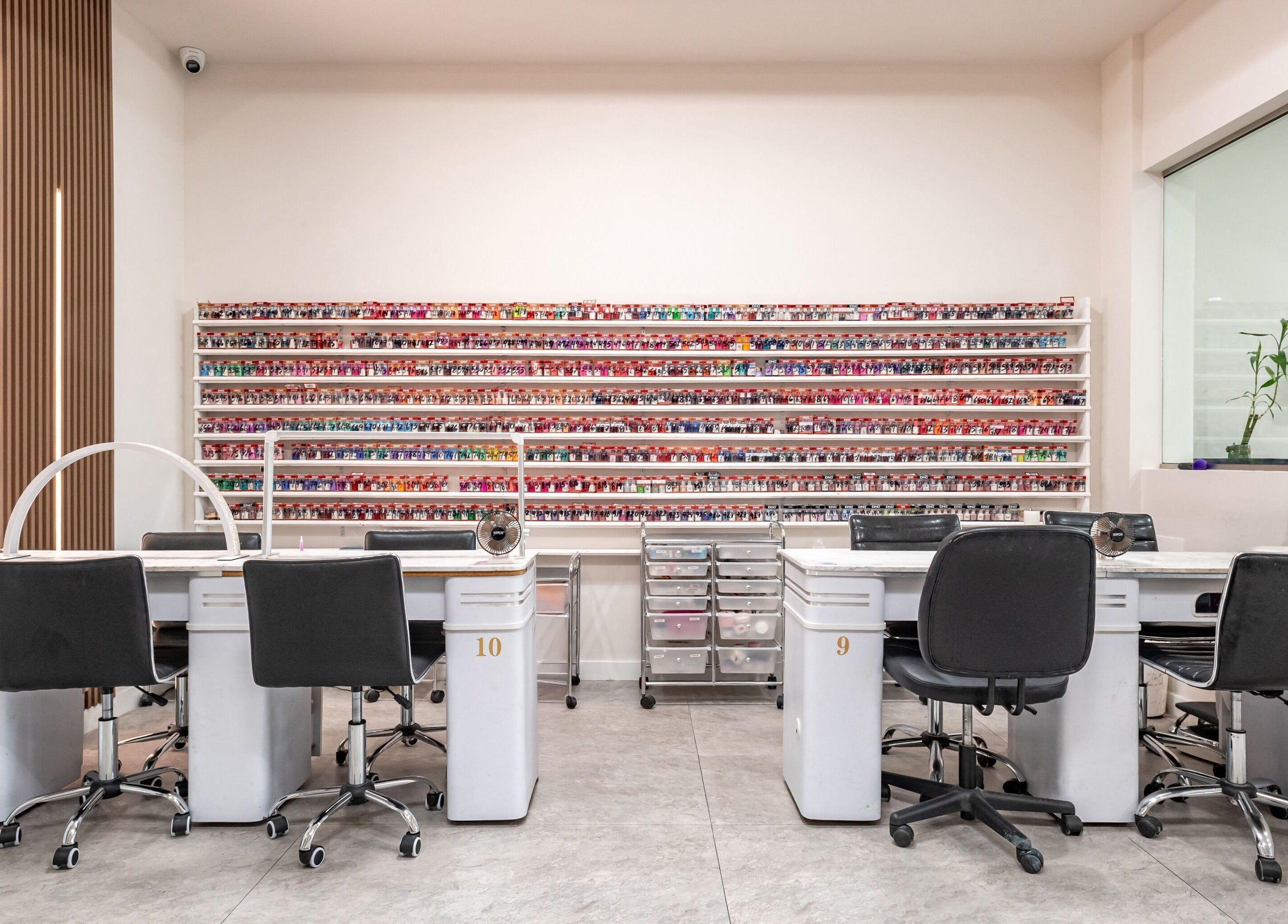 Modern nail salon at Lash and Nail Spa in Miramar, Florida, US with chairs, tables, and vibrant polish display.