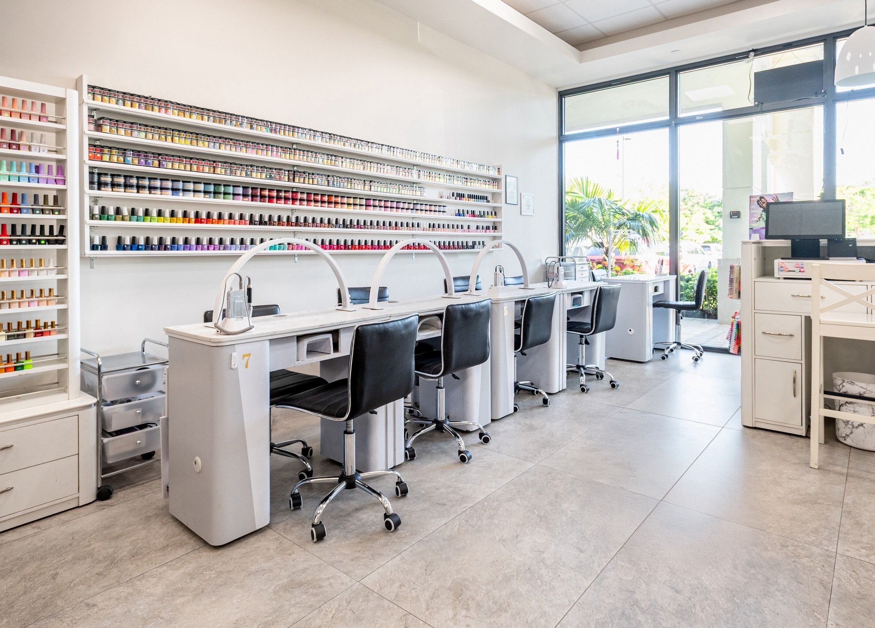 Spacious interior of Lash and Nail Spa in Miramar, Florida, US, featuring a vibrant nail polish display and workstations.