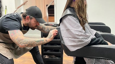 Stylist at Travis Manning Hair Consultant in Great Yarmouth, England, performing a detailed haircut.