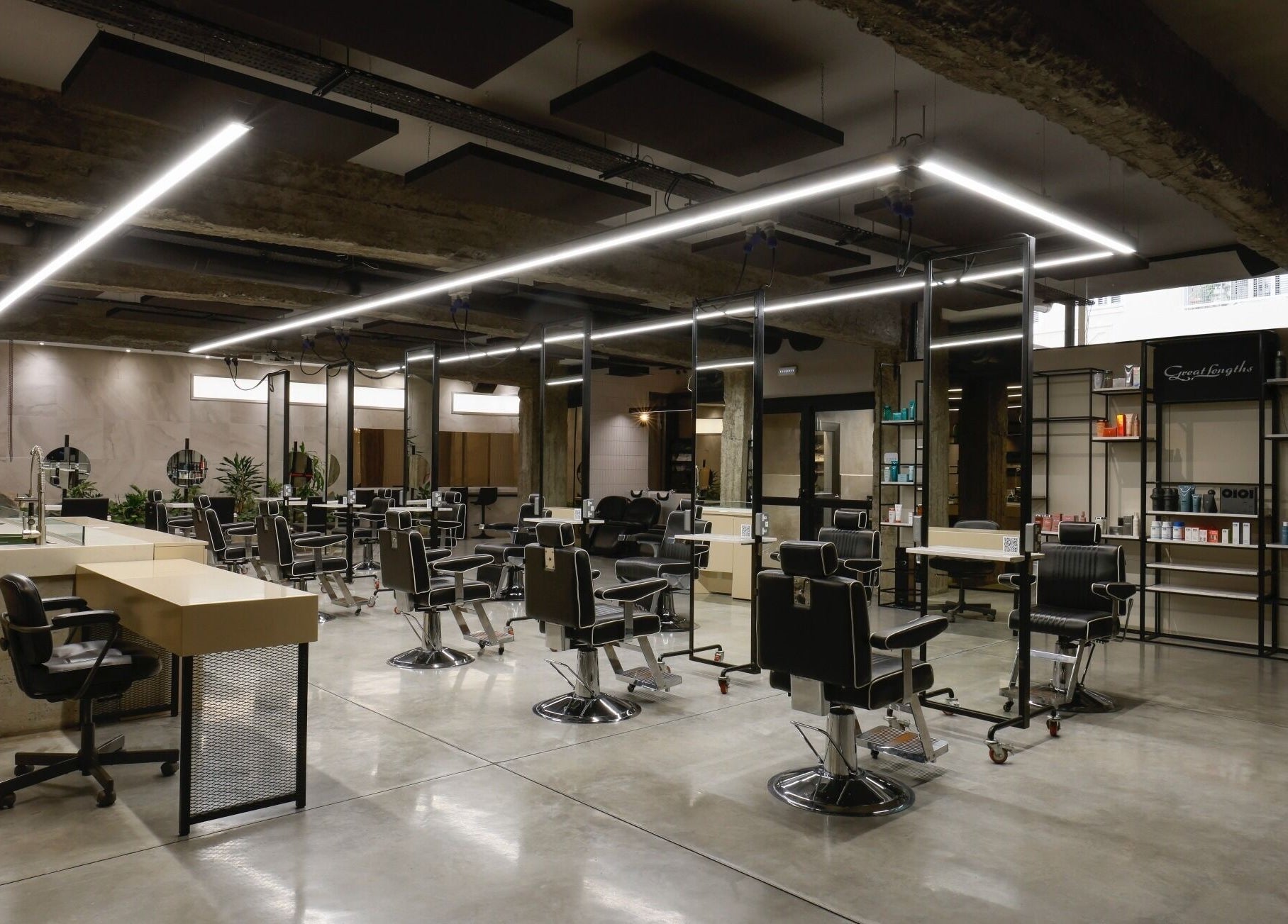 Modern interior of HAIR ETC. Studio in Nicosia, CY featuring sleek black salon chairs and elegant lighting.