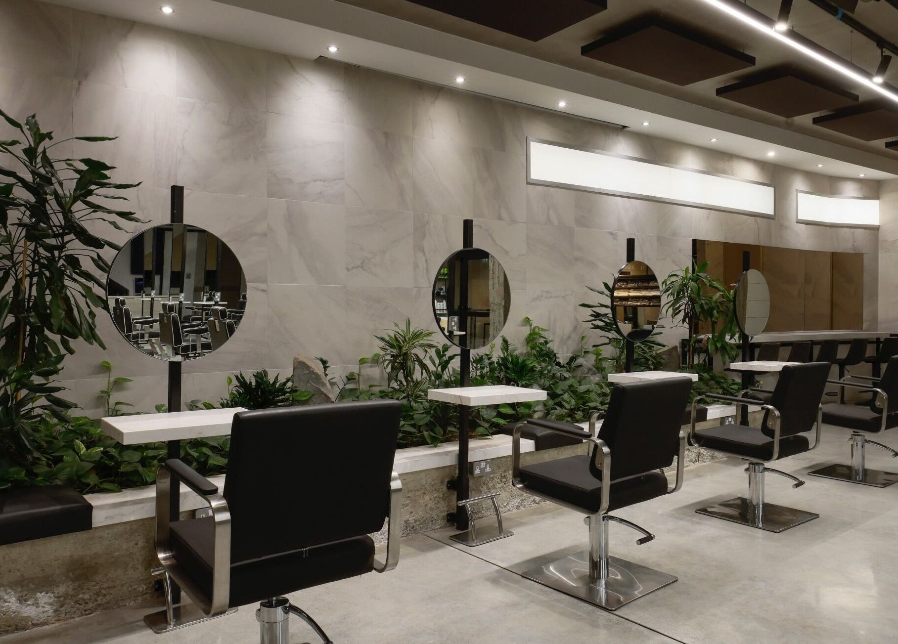 Modern salon interior at HAIR ETC. Studio, Nicosia, CY, featuring sleek styling chairs and vibrant plants.