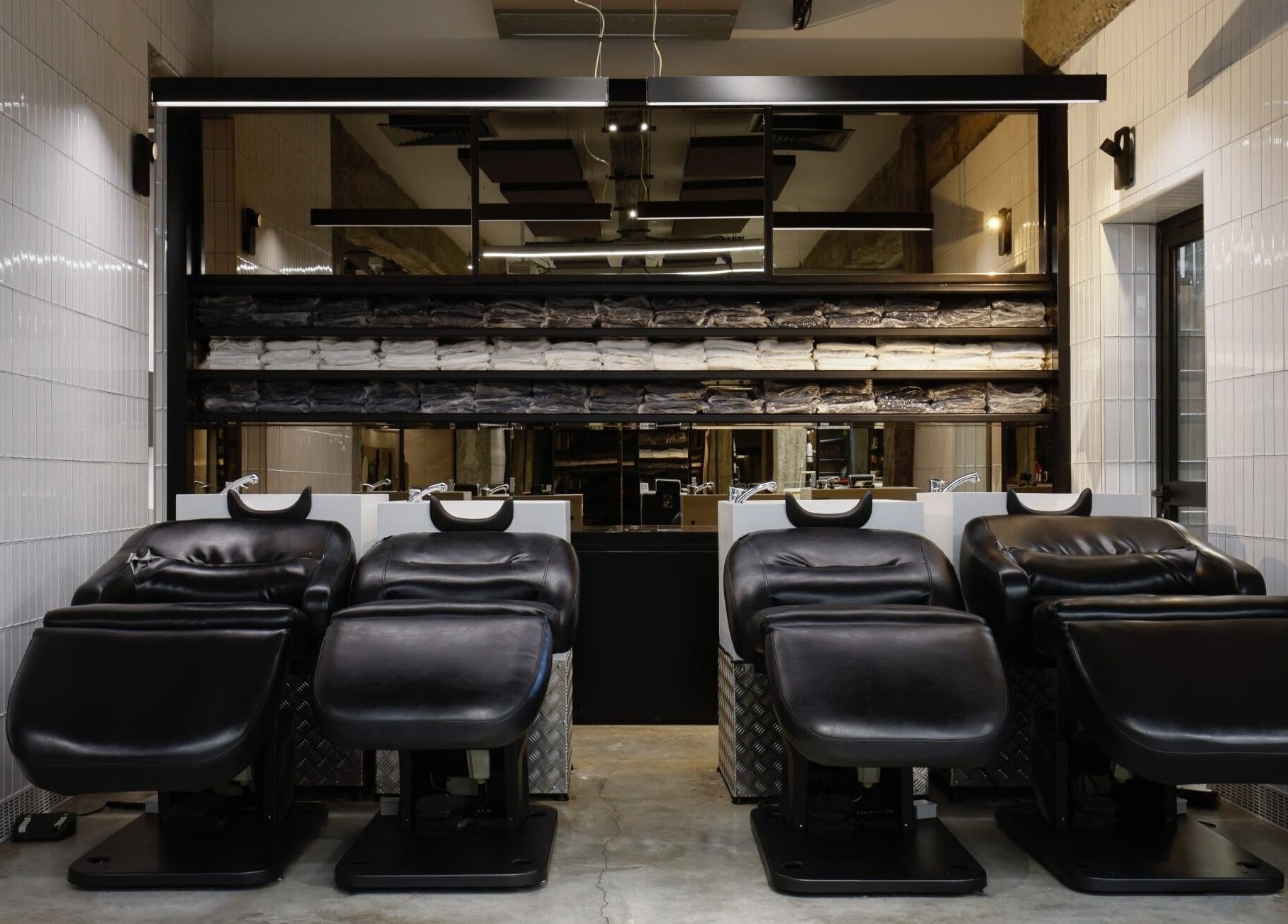 Elegant shampoo chairs at HAIR ETC. Studio, Nicosia, CY, with neatly arranged towels in the background.