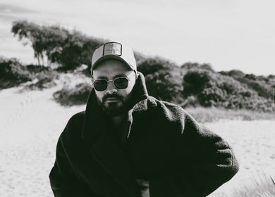 Man in stylish coat and cap at a sandy beach near David Nukri, Frederiksberg, Denmark, DK.