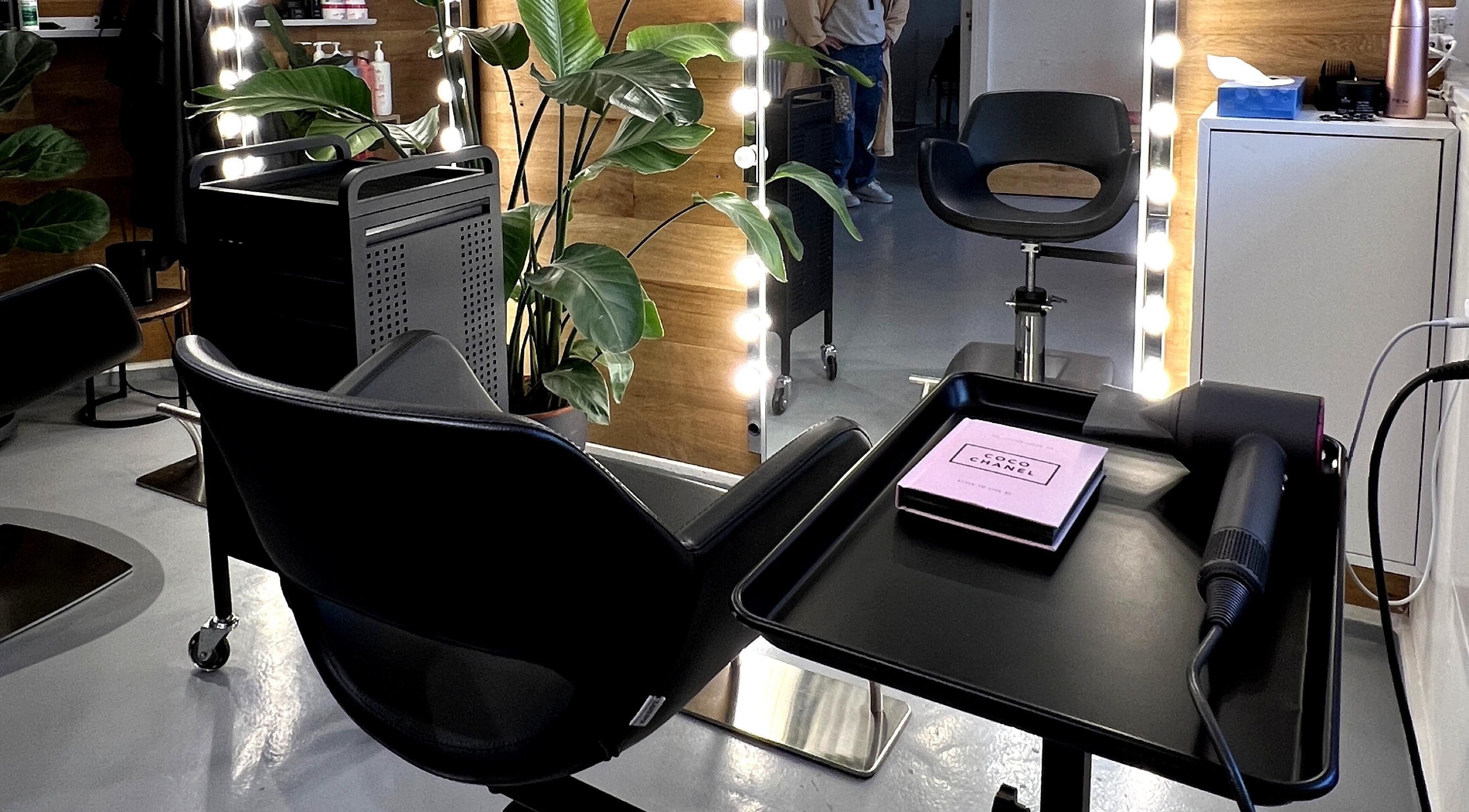 Modern beauty salon at David Nukri, Frederiksberg, Denmark, DK with sleek chairs and illuminated mirrors.
