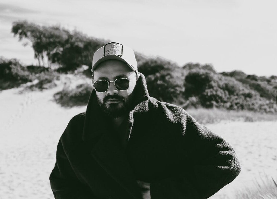 A stylish individual in coat and cap at David Nukri, Frederiksberg, Denmark, DK.