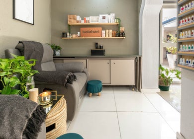 Relaxing lounge at Golden Olive | Nail & Lash Bar in Cape Town, Western Cape, ZA, with cozy seating and lush plants.