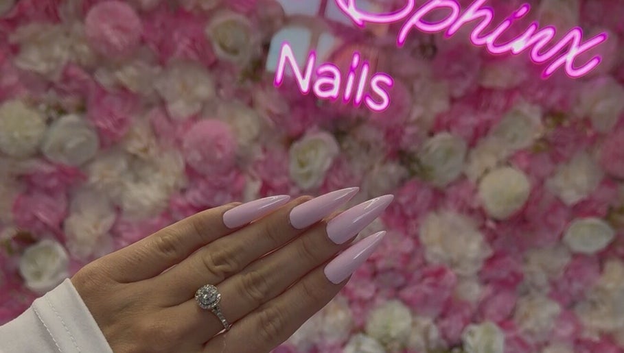 Elegant pink manicure at Pink Sphinx Nails, Binbrook, Ontario, CA with floral backdrop.