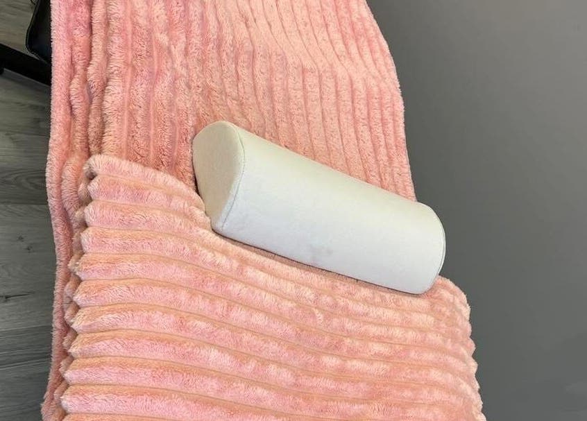 Plush pink blanket and cushion at LJMs Beauty Bar in Ayr, Scotland, GB, offering a cozy spa experience.