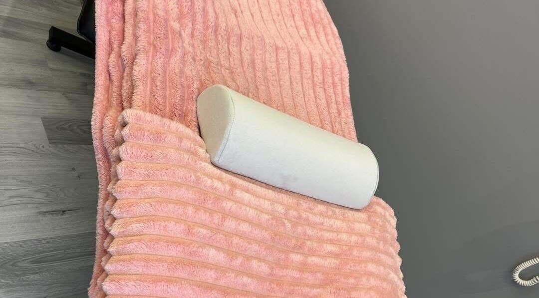 Plush pink blanket and cushion at LJMs Beauty Bar in Ayr, Scotland, GB, offering a cozy spa experience.