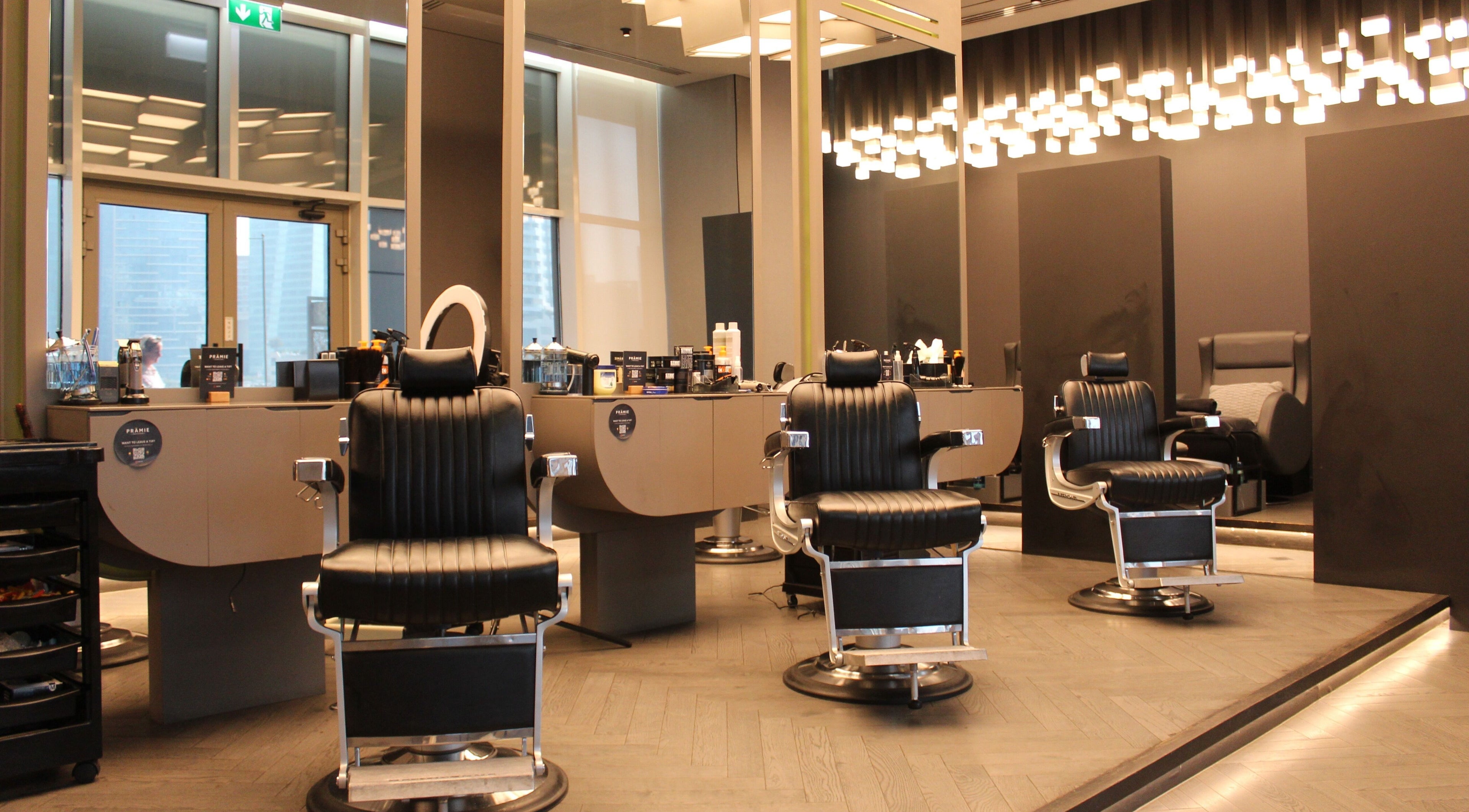 Sophisticated interior at Pramie Gents Salon, Dubai, Dubai, AE, featuring sleek black barber chairs.