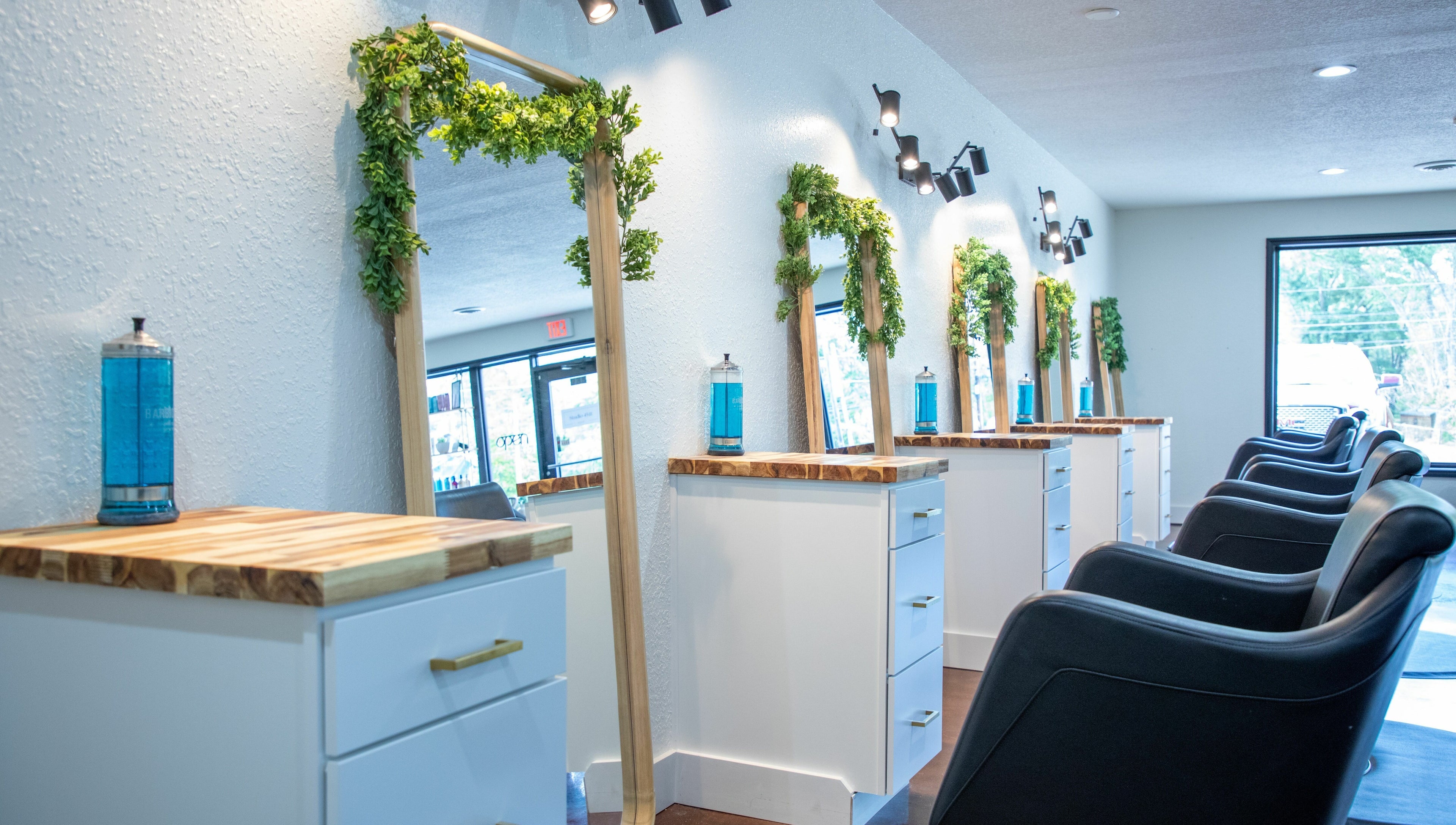 Stylish interior of Studio 45:11 Salon in Seymour, Tennessee, US featuring sleek mirrors and modern chairs.