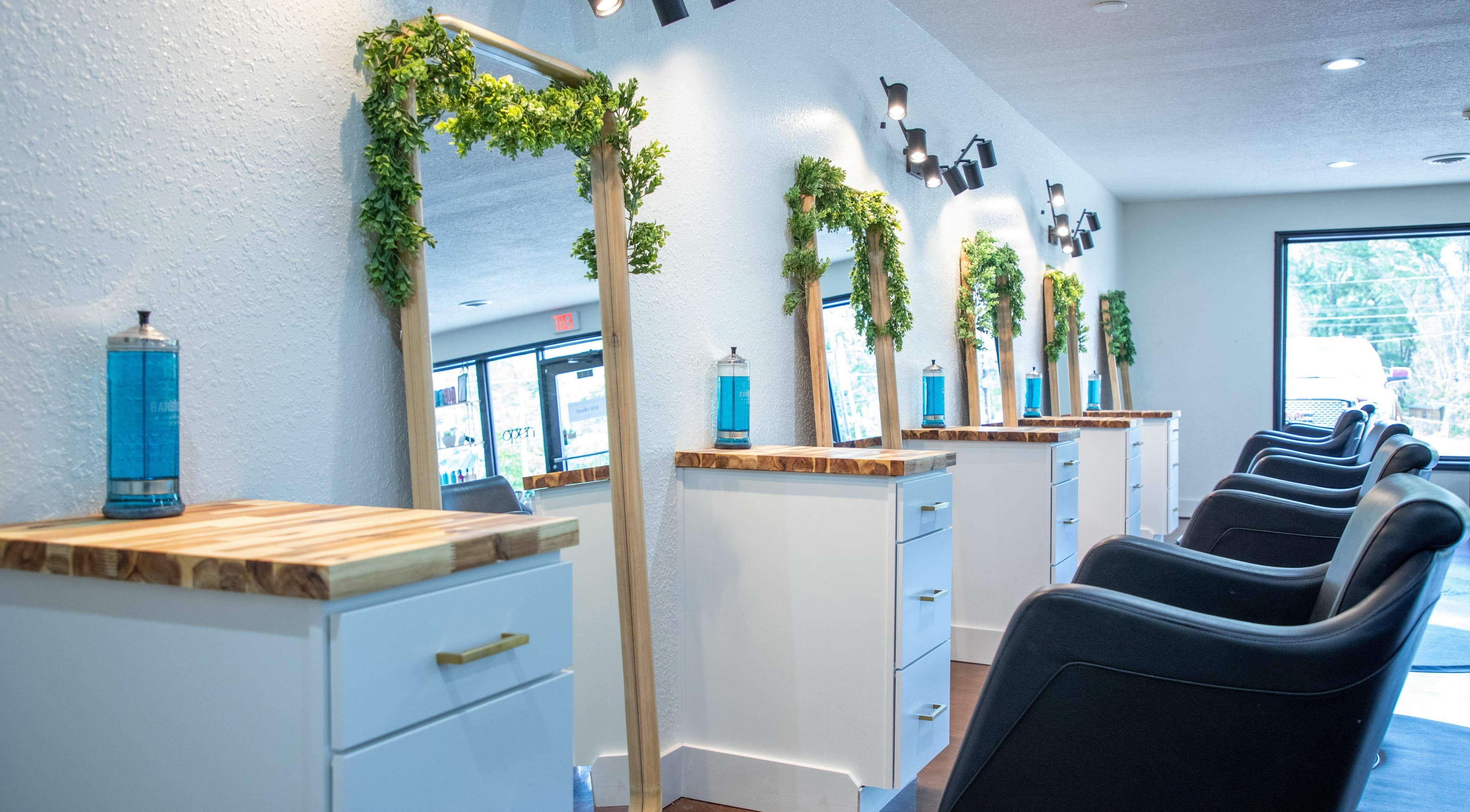 Stylish interior of Studio 45:11 Salon in Seymour, Tennessee, US featuring sleek mirrors and modern chairs.