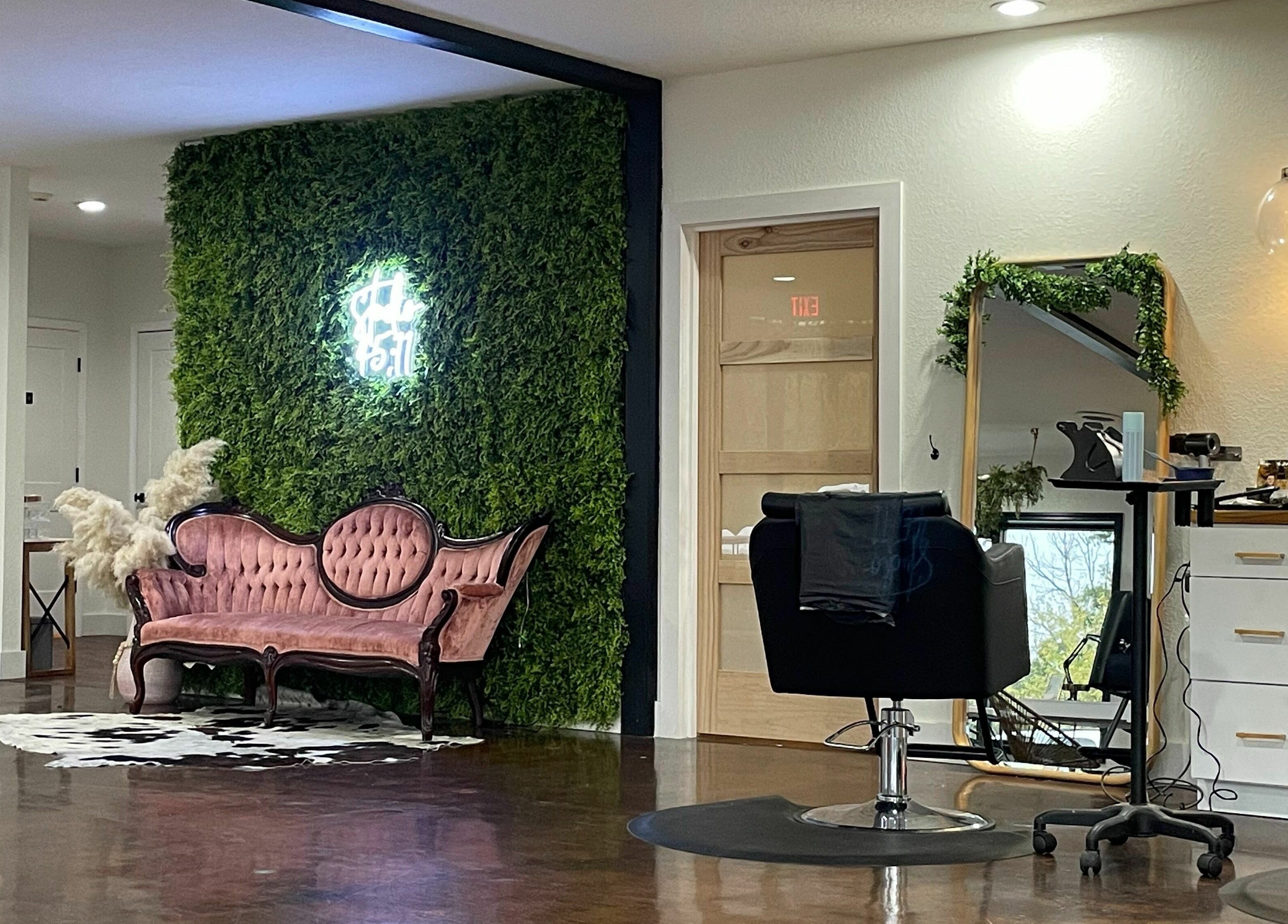 Chic interior of Studio 45:11 Salon in Seymour, Tennessee, US with a vintage sofa and green wall.