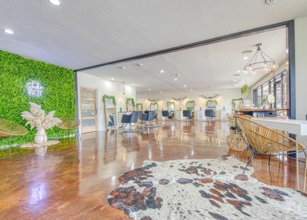 Modern interior of Studio 45:11 Salon in Seymour, Tennessee, US with green wall and stylish seating.