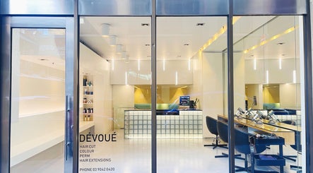 Modern interior of Devoue Hair in Melbourne, Victoria, AU with sleek styling stations and illuminated reception.