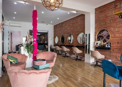 Cozy salon interior at M.O.H & Co, Melbourne, Victoria, AU featuring chic pink seating and elegant decor.
