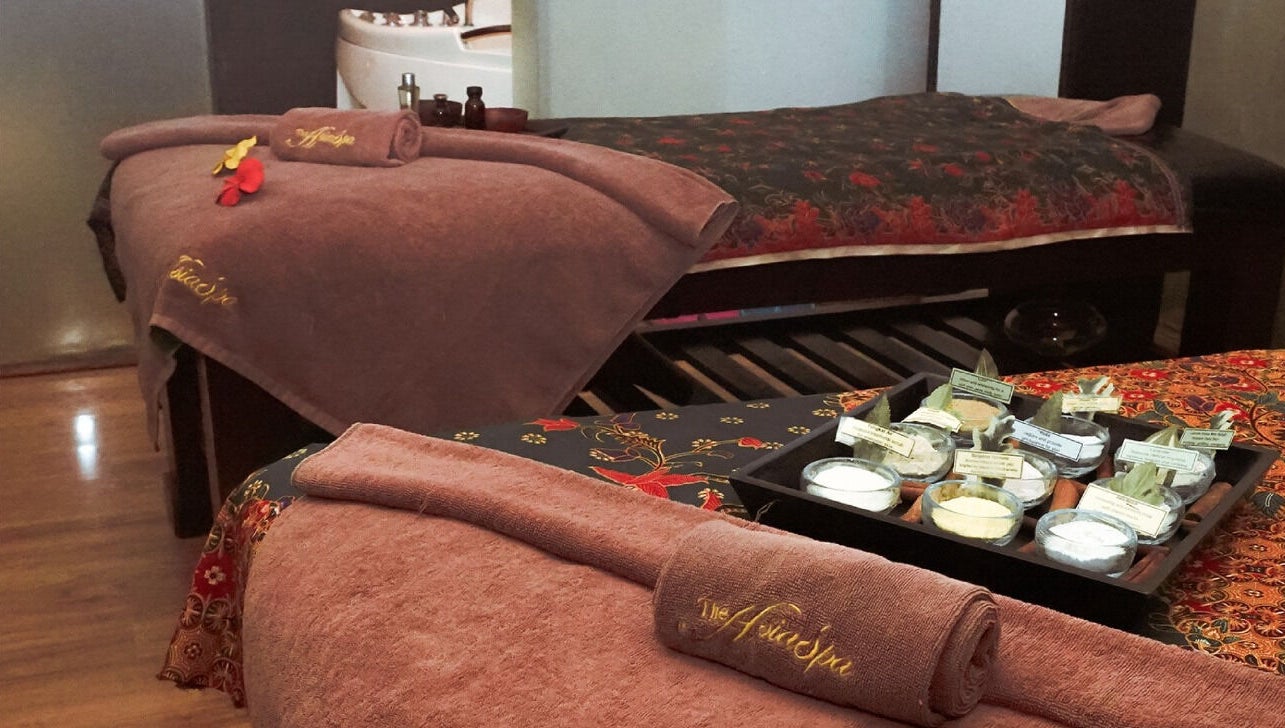 Relaxing spa beds at The AsiaSpa, Kuala Lumpur, Wilayah Persekutuan Kuala Lumpur, MY with towels and floral decor.