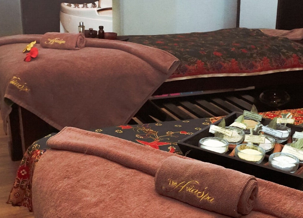 Relaxing spa beds at The AsiaSpa, Kuala Lumpur, Wilayah Persekutuan Kuala Lumpur, MY with towels and floral decor.