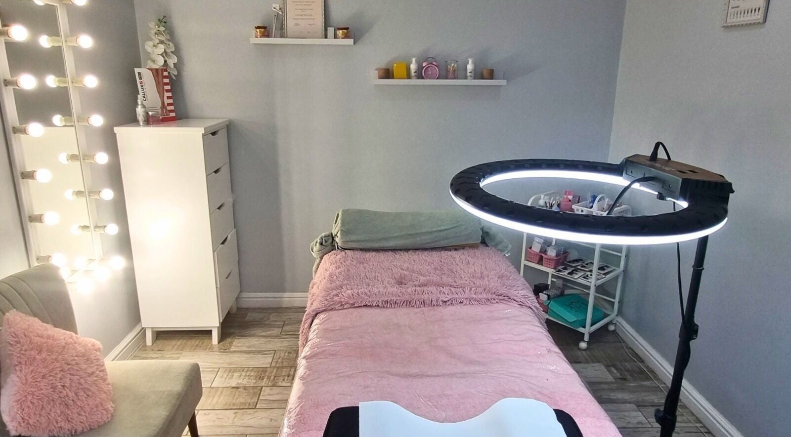 Cozy treatment room at Minutiae Beauty, Cape Town, Western Cape, ZA with plush bed and vibrant lighting.