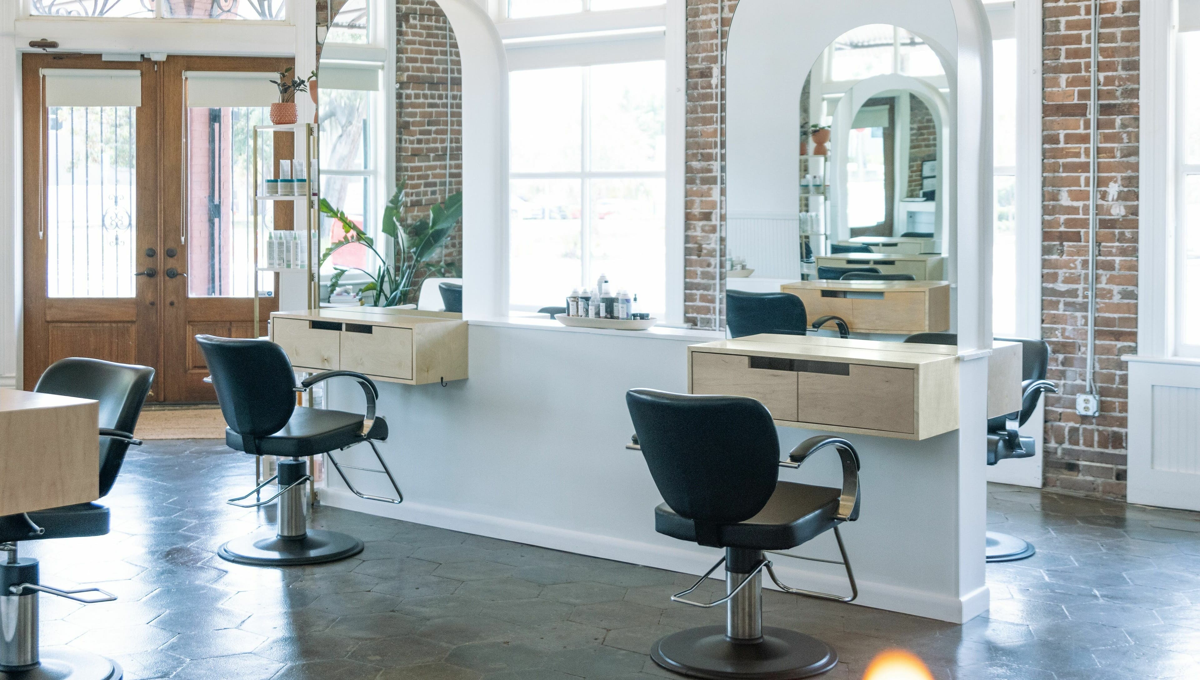 Chic salon interior with styling chairs and mirrors at MATERIAL - Tampa, located in Tampa, Florida, US.