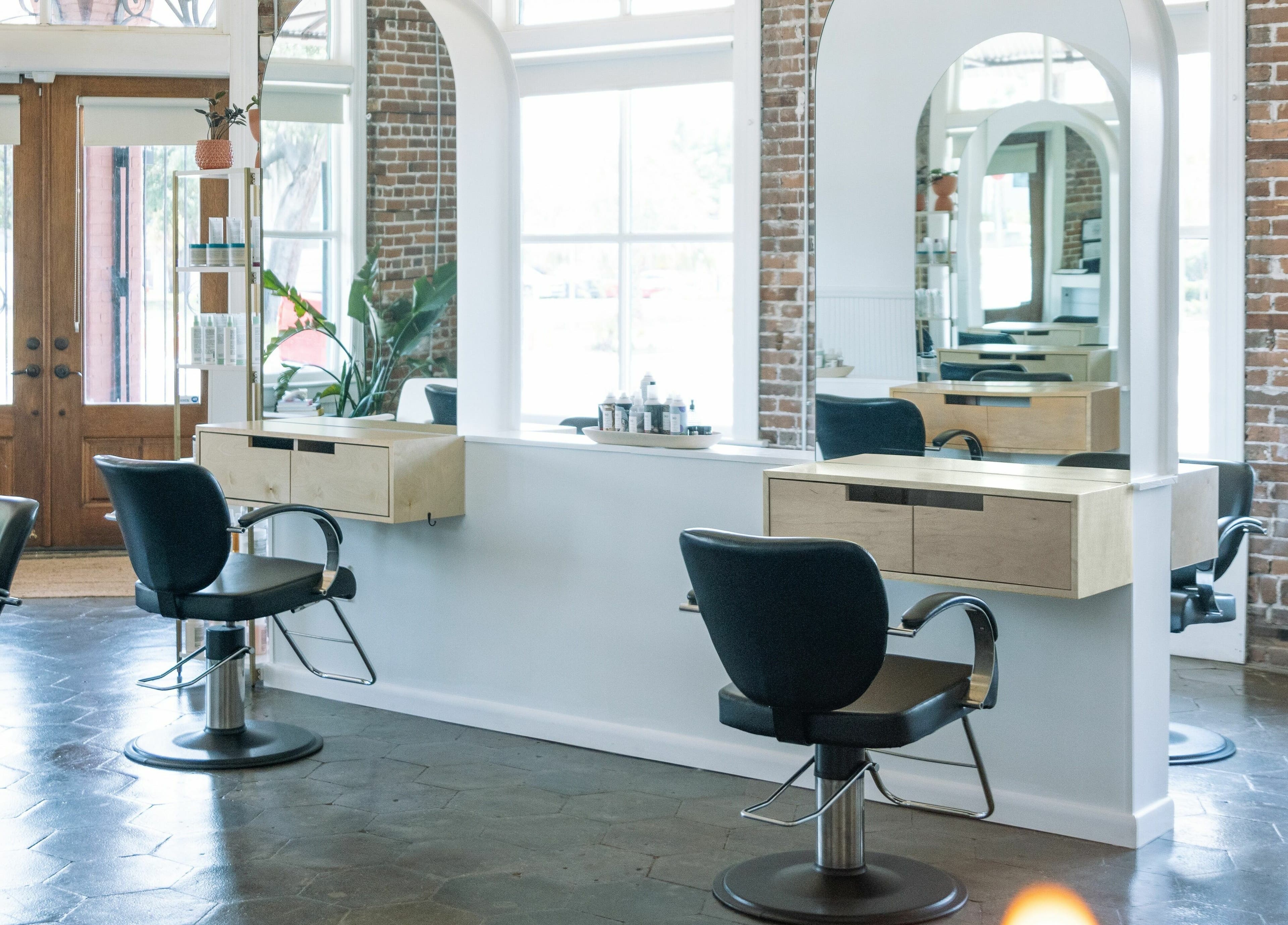 Chic salon interior with styling chairs and mirrors at MATERIAL - Tampa, located in Tampa, Florida, US.