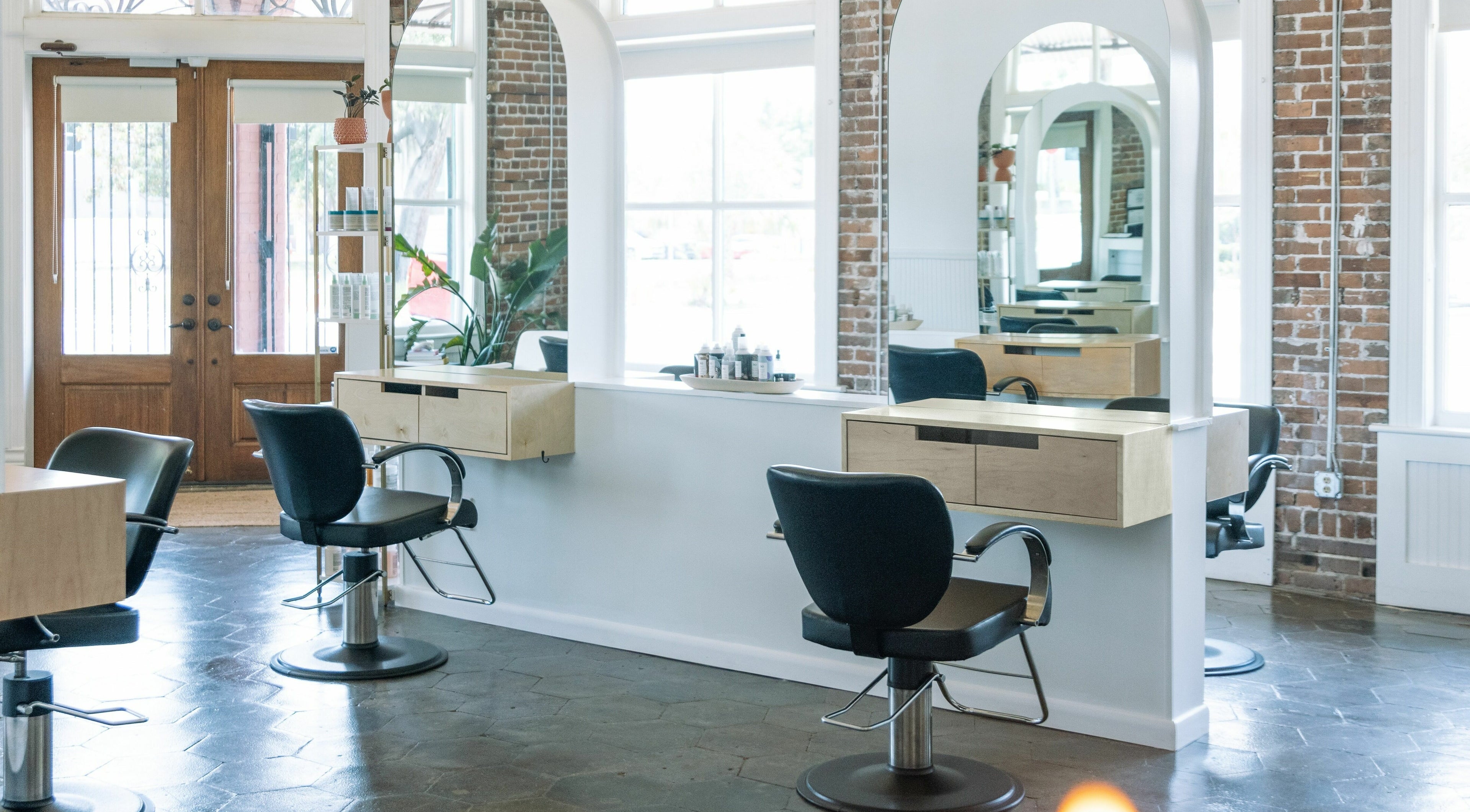Chic salon interior with styling chairs and mirrors at MATERIAL - Tampa, located in Tampa, Florida, US.
