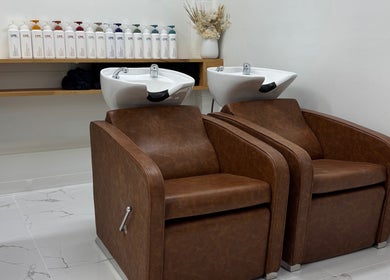Elegant wash stations at Melt Salon Collective in Nelson Bay, New South Wales, AU, featuring leather chairs and modern sinks.