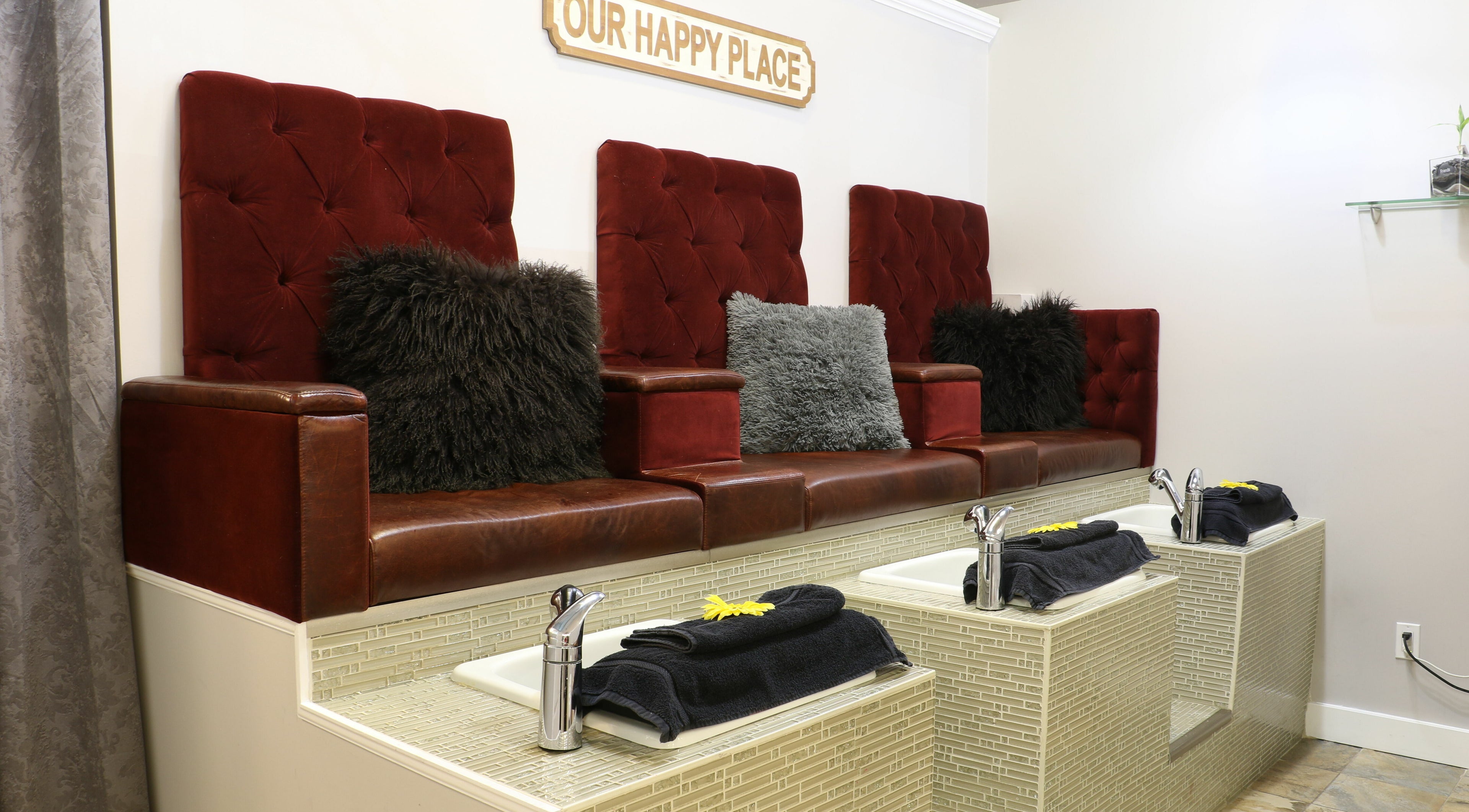 Luxurious pedicure seating at Boulevard Salon and Esthetics, Surrey, British Columbia, CA, with rich red upholstery.