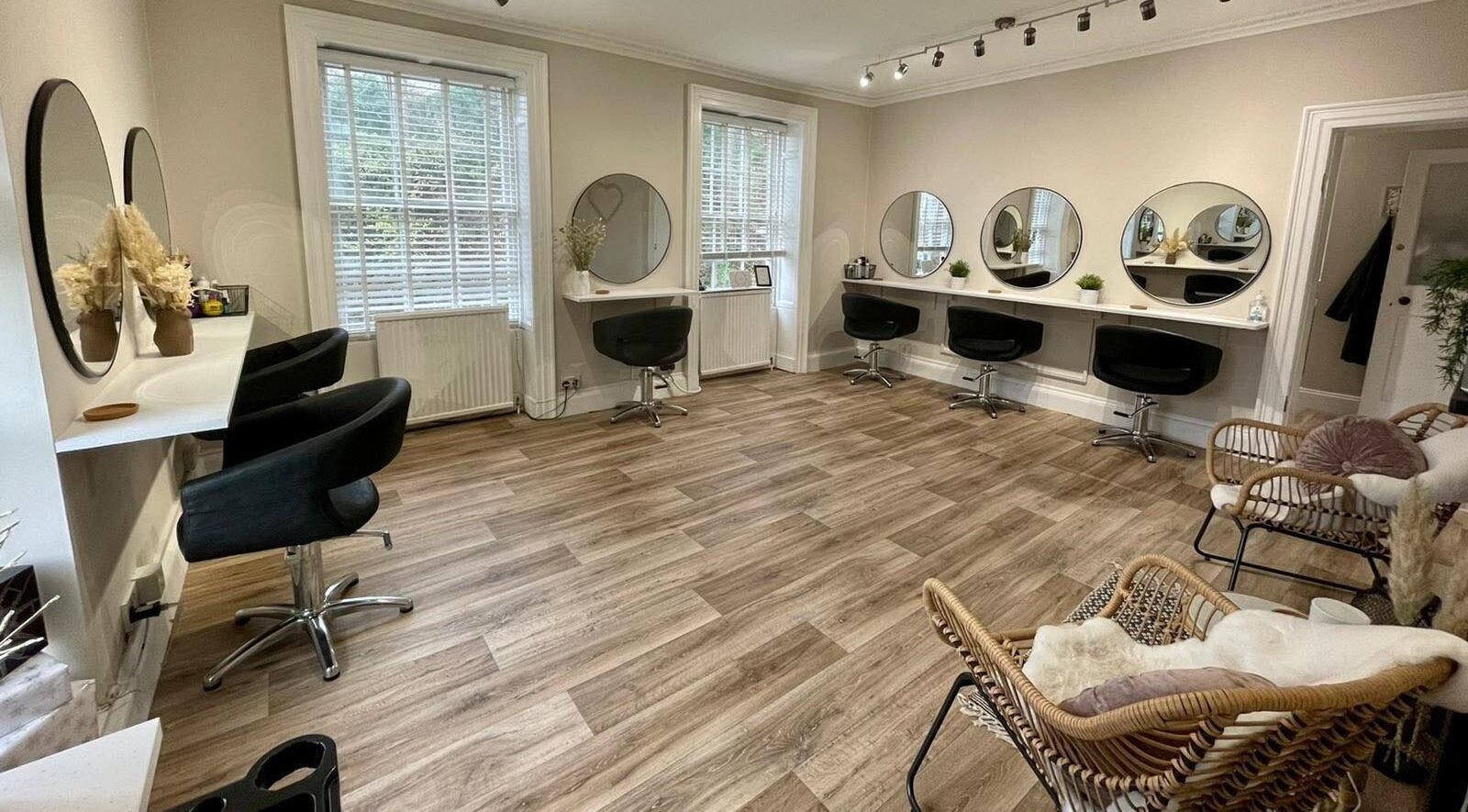 Spacious salon interior at Wilder in Stroud, England, GB with stylish chairs and mirrors.