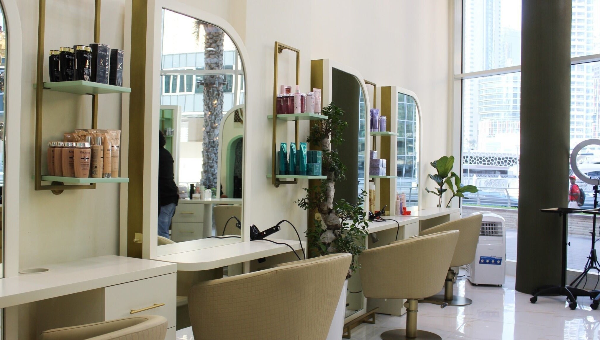 Modern styling stations at Blond Me Salon, Dubai, AE with sleek chairs and beauty products displayed.
