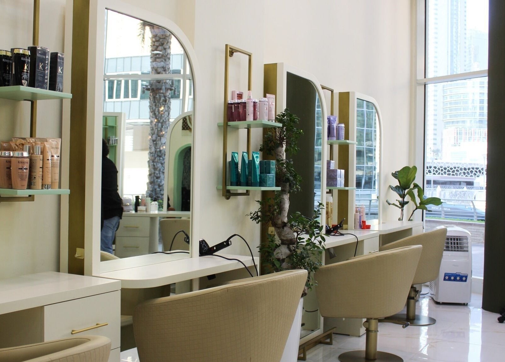 Modern styling stations at Blond Me Salon, Dubai, AE with sleek chairs and beauty products displayed.