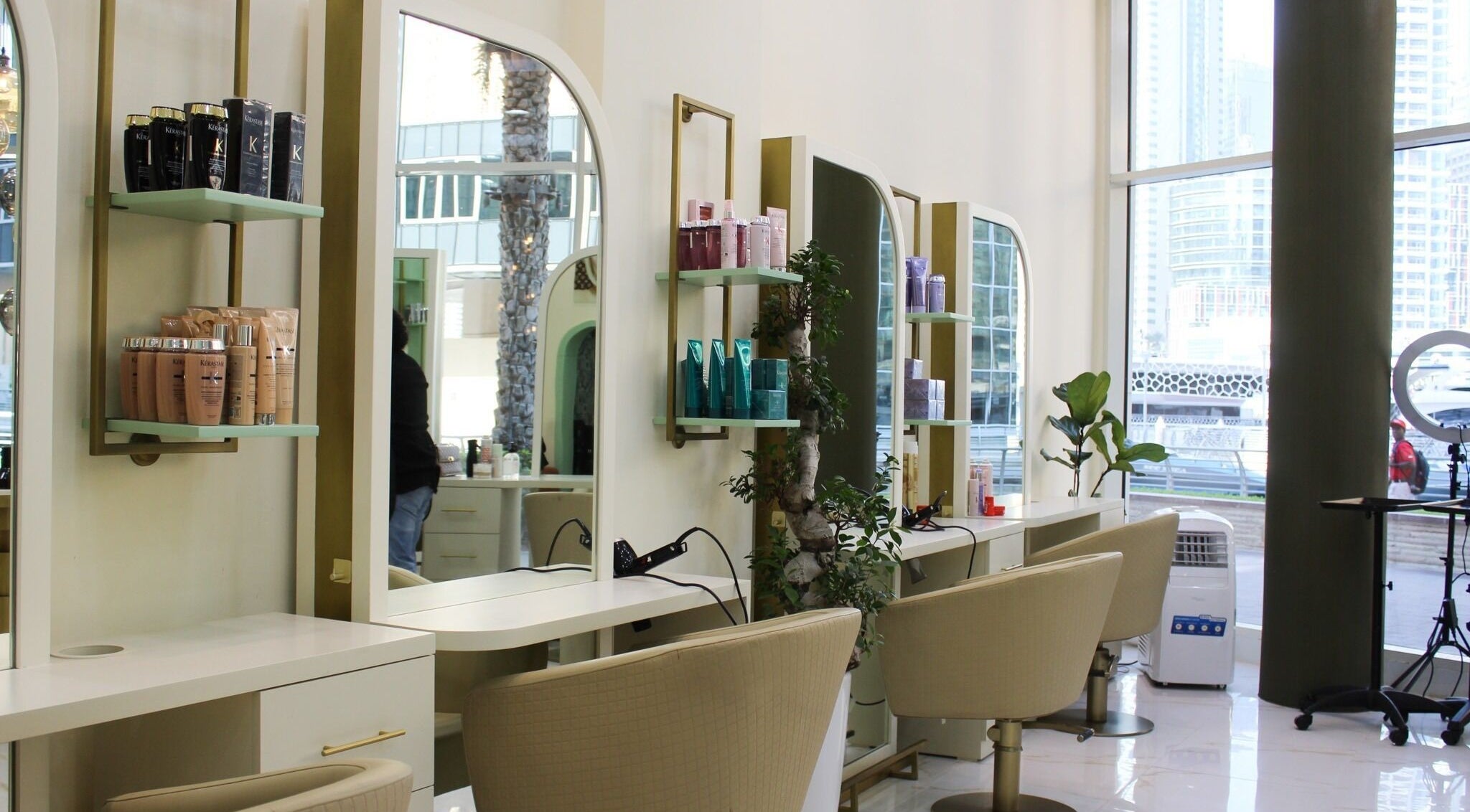 Modern styling stations at Blond Me Salon, Dubai, AE with sleek chairs and beauty products displayed.