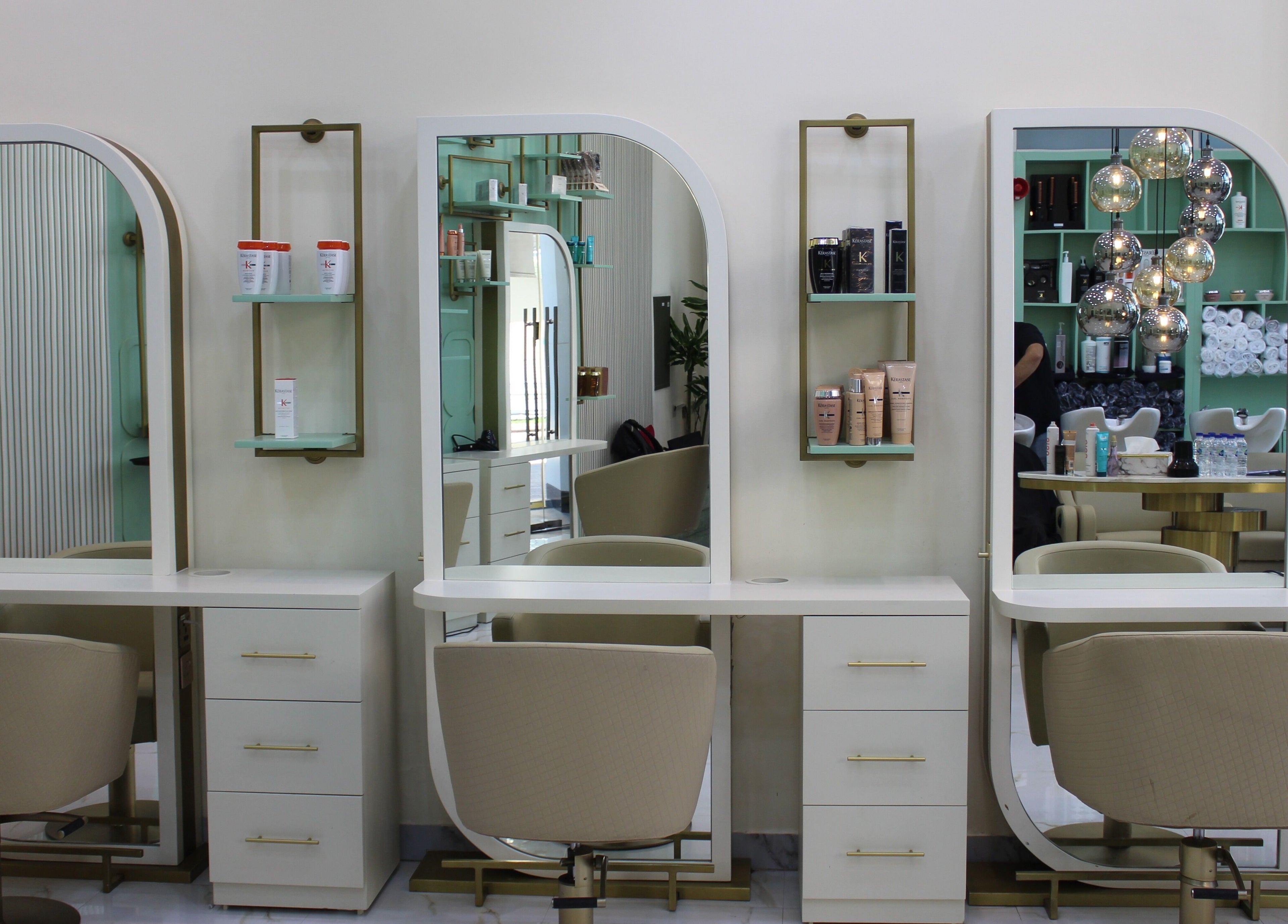 Luxurious styling stations at Blond Me Salon, Dubai, AE, showcasing elegant mirrors and salon chairs.