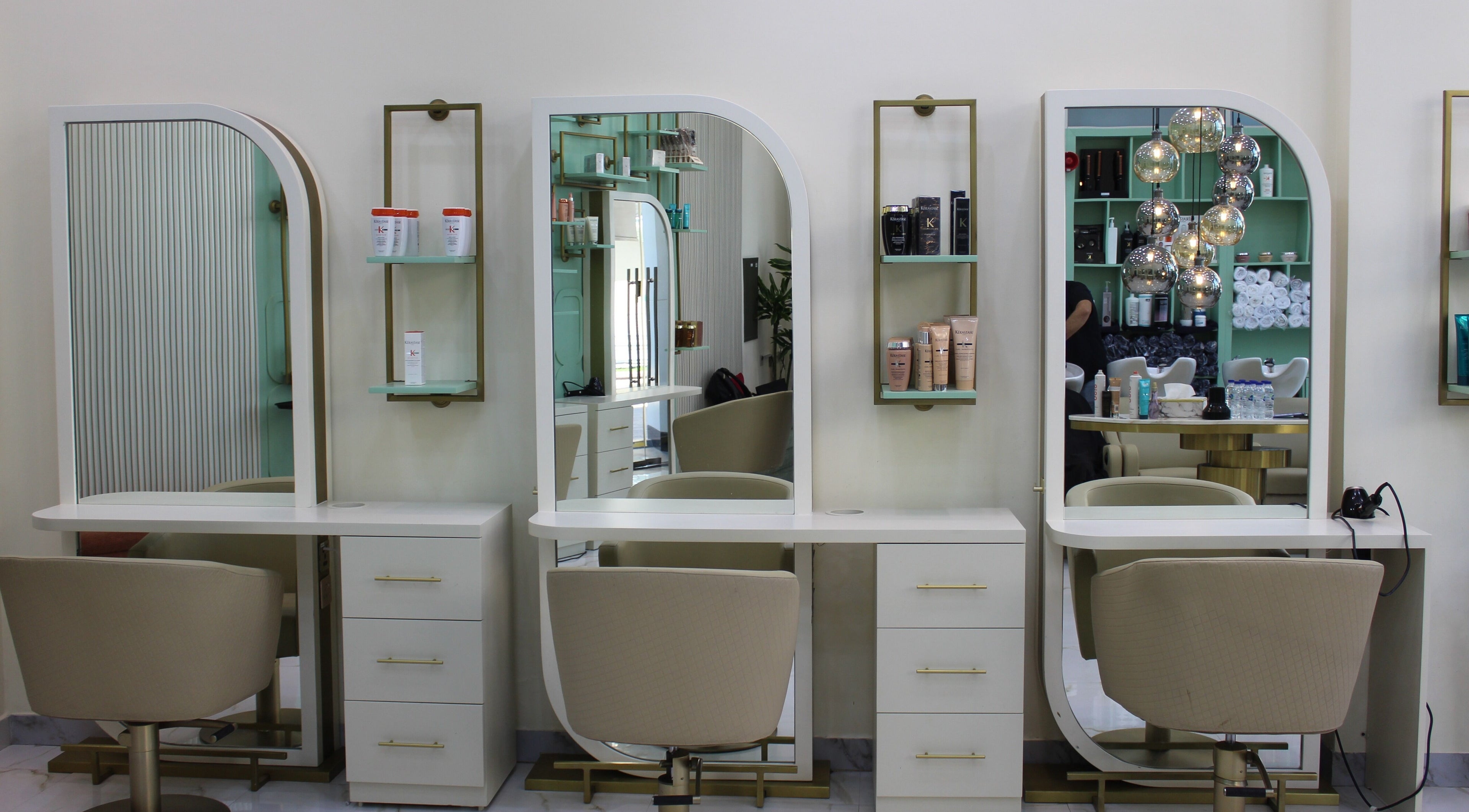 Luxurious styling stations at Blond Me Salon, Dubai, AE, showcasing elegant mirrors and salon chairs.