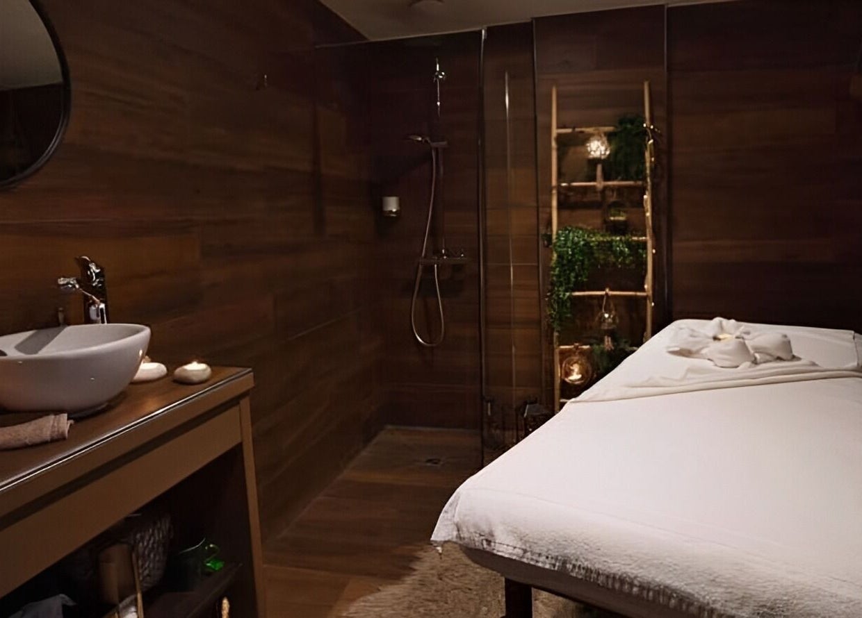 Salle de massage apaisante à O'thera Spa, Poissy, Île-de-France, FR avec table et lavabo moderne.