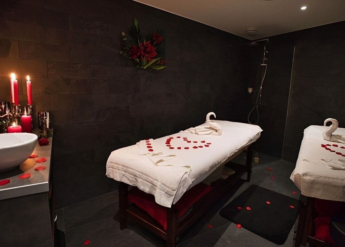 Salle de massage romantique avec décor pétales à O'thera Spa, Poissy, Île-de-France, FR.